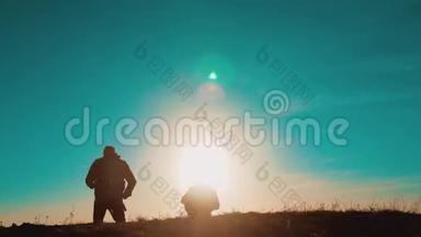 团队合作智能手机导航。 两名游客徒步旅行者在日落时带着背包去徒步旅行。 徒步旅行者冒险
