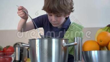 小男孩笑着在厨房里煮汤