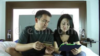 快乐的年轻夫妇在平板电脑上上网购物