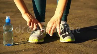 女孩停止跑步，把鞋带系在<strong>跑鞋</strong>上。 <strong>健身</strong>女孩在户外训练。 4K