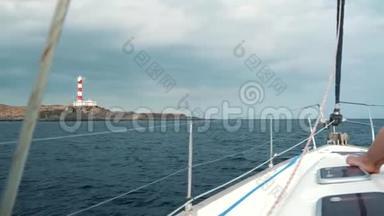 一位戴着黄色帽子，穿着蓝色裙子的女士在海洋的夏季靠近灯塔的游艇上休息