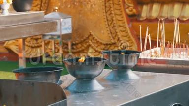 在佛寺，人们用烟点燃火棍。 泰国。 帕塔亚
