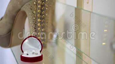 盒子里的金色结婚戒指和桌子上的新娘鞋