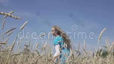 在阳光明媚的日子里，年轻的女人穿着蓝色的裙子，在成熟的麦子里留着一头长长的长发，动作缓慢