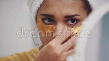 一幅美丽女人洗澡后用毛巾在头上的特写肖像，将皱纹贴在眼睛下面