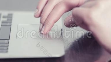 女人的手在便携式电脑上用触控板