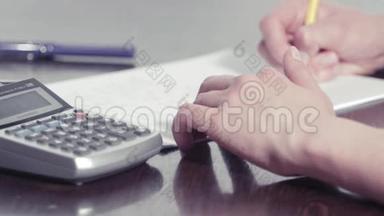 女人用铅笔写字，用计算器打字