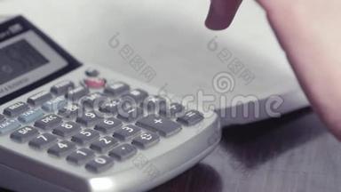 女人的手在计算器上打字