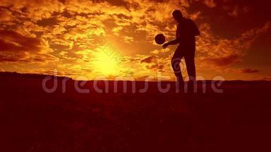 足球运动员填充球剪影人踢球在空中生活方式与日落背景。 男人踢足球