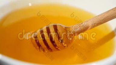 在盛满蜂蜜的碗里，用蜂蜜蘸汁把蜂蜜滴上