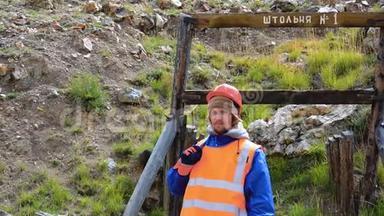 采矿工程师，<strong>地质</strong>学家，穿着防护反光背心，手套和头盔，手里拿着锤子。