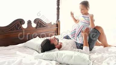 幸福<strong>的家庭</strong>，<strong>我的</strong>小女儿跳到父亲<strong>的</strong>手臂上，他们躺在床上