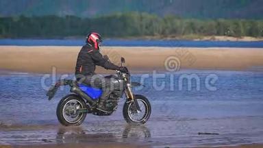 自由的感觉和莫托美学.. 摩托车手在沙滩上骑自行车。