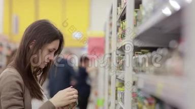 年轻女子在商店里选择罐头食品