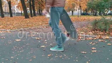 滑板手推滑板，继续走秋季公园
