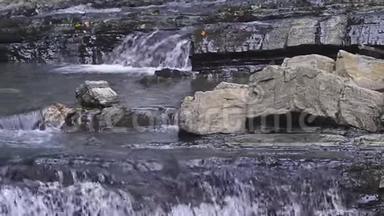 特写镜头。 落石山上的瀑布。 水流迅速下坠，生成白色起泡泡沫.. 石头瀑布