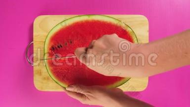 俯视图，女手用刀在木板上<strong>切水果</strong>，红色西瓜.. 天然健康食品的概念..