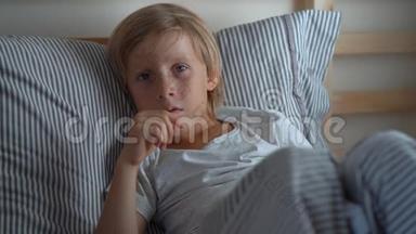 在床上生病的小男孩。 男孩在床上咳嗽。 婴儿流感概念