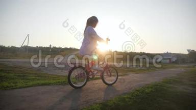 骑自行车的<strong>孩子</strong>在日落时骑自行车享受自由。 日落时骑自行车在<strong>乡下</strong>的女孩。