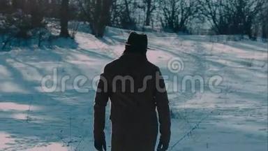 一个戴着毡帽和外套的人来到冬天的树林里。 毛毡制的棕色帽子和棕色外套