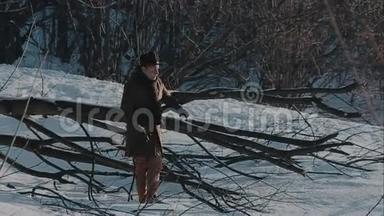 一个戴着毡帽和外套的人来到冬天的树林里。 毛毡制的棕色帽子和棕色外套
