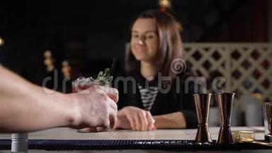酒保给那位漂亮的黑发女人放了一杯独家鸡尾酒。 酒吧里的幽默和笑声