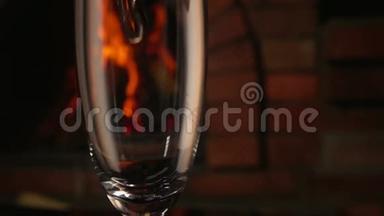 香槟酒在火的背景下倒入玻璃杯中