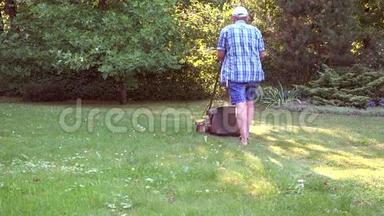在花园里用割草机割草的人。 4K