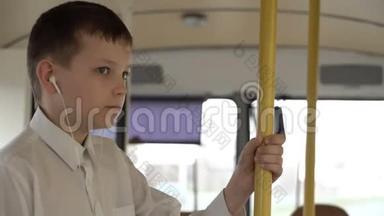 一个小<strong>男孩</strong>乘公共汽车穿过城市的特写镜头。 他<strong>听音乐</strong>。