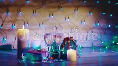 圣诞礼物、蜡烛和<strong>两杯香槟</strong>蓝色花环背景
