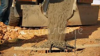 施工人员在施工现场用混凝土搅拌车将混凝土浇筑到地面的一个孔中