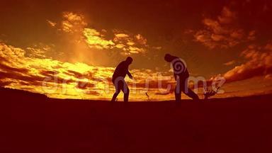 两名男子足球运动员在日落时玩球剪影慢户外运动视频。 男人是欧洲人