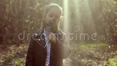 美丽的小女孩在阳光明媚的日子里享受大自然。 可爱的孩子在森林里玩耍和远足，早春的花。