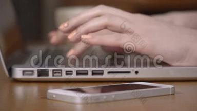 特写一只女手忙着在笔记本电脑上打字。