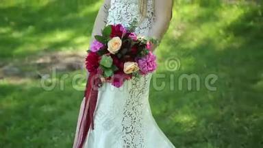 带火车的婚纱。 美丽的<strong>婚礼</strong>花束在年轻新娘手中。 <strong>婚礼</strong>。 公园里的年轻女子