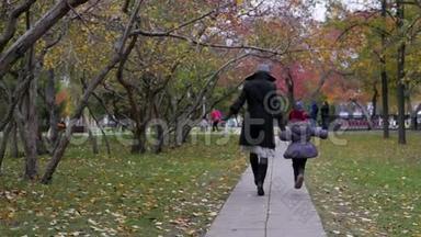 一个年轻的女人和她的女儿在公园里走来走去，在小巷里玩耍和奔跑