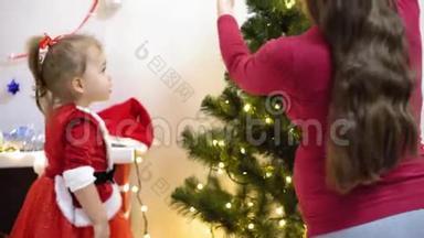 宝宝和<strong>孕妈</strong>在圣诞树上挂红球玩具。 快乐的童年概念。 孩子和母亲用
