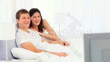 年轻夫妇在电视前大笑