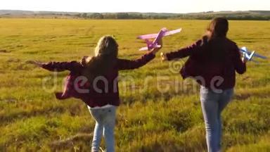 孩子们在飞机上玩耍的剪影。 飞行的梦想。 快乐的童年概念。 两个女孩玩玩具飞机