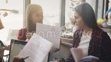 两个女商人一起讨论文件，合作伙伴讨论计划或想法和意见会议