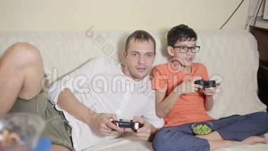 <strong>父亲和儿子在家里</strong>的沙发上玩电子游戏