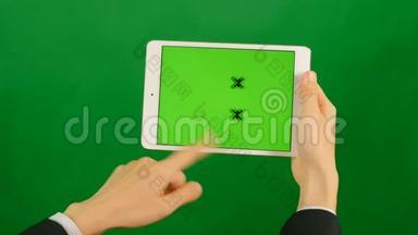 女商人在绿色背景上使用空白的绿色屏幕平板电脑。
