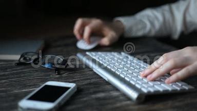 一个现代化的工作场所。 夜间工作。 一个<strong>人坐</strong>在<strong>电脑前</strong>，在键盘上打字。