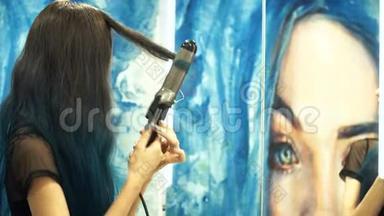 漂亮，年轻的女<strong>人</strong>在浴室镜子前卷发。 头发烫发。 带有艺术绘画的浴帘。