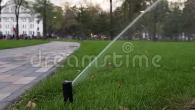 园灌喷灌<strong>浇水草坪</strong>在园区走道附近.. 自动旋转灌溉系统。 青草