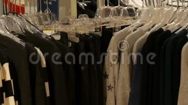 时尚的衣服挂在商场服装店的衣架上。
