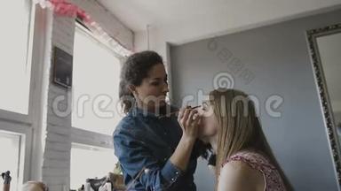 化妆师在照相馆为一个非常漂亮的女孩做专业的化妆