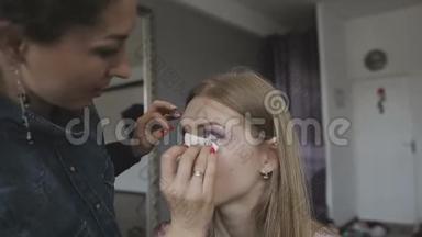化妆师在照相馆为一个非常漂亮的女孩做专业的化妆