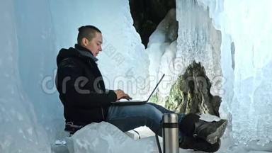 人们坐在冰<strong>洞</strong>里的笔记本电<strong>脑</strong>上。 围绕着神秘美丽的冰窟.. 用户在