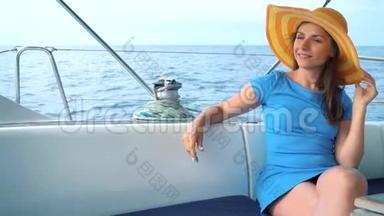 戴着黄色帽子的女人和穿着蓝色衣服的女孩在海洋的夏季在游艇上休息